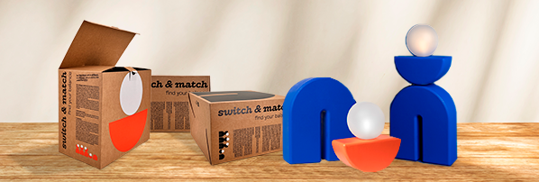 coffret Switch & Match avec lampe design modulaire et boîte kraft ouverte, carton empilés orange et bleu